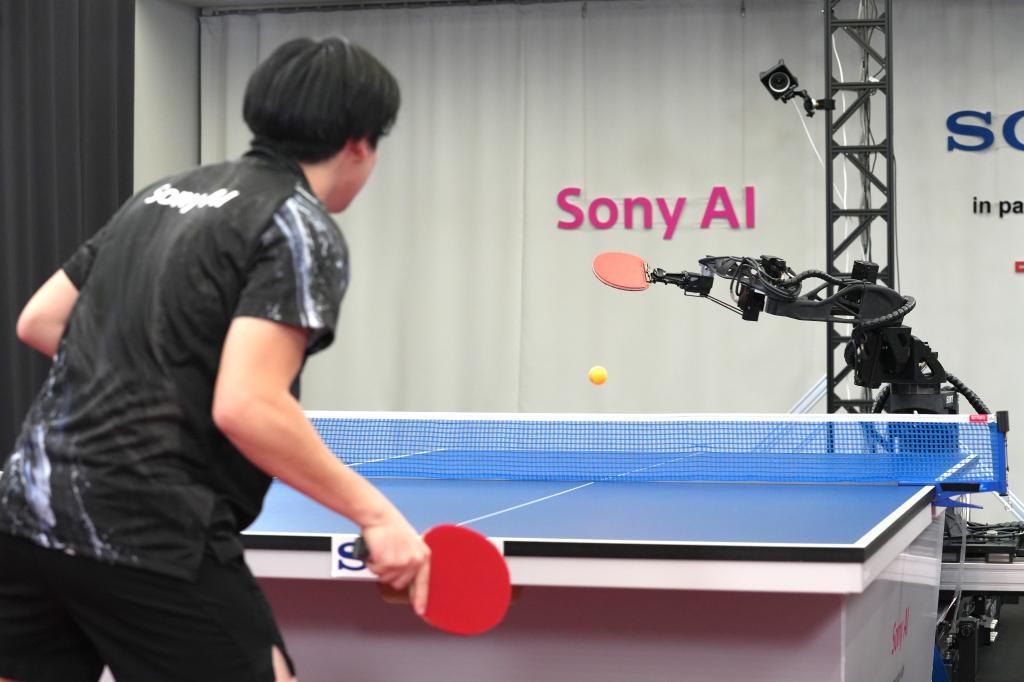 A table tennis robot built by Sony maneuvers to hit the ball back to its human opponent