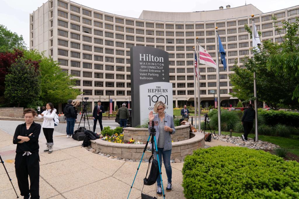 Journalists gather outside of the Washington Hilton Hotel