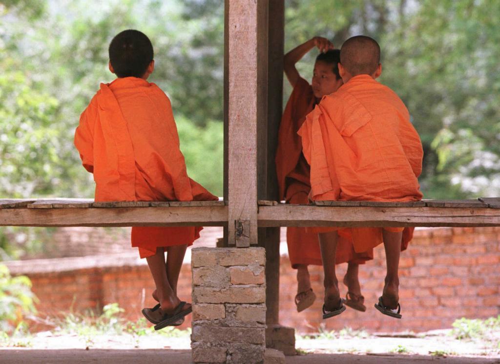 Three children, young Buddhist monks, play in a pagoda at the Mansha temple in China.