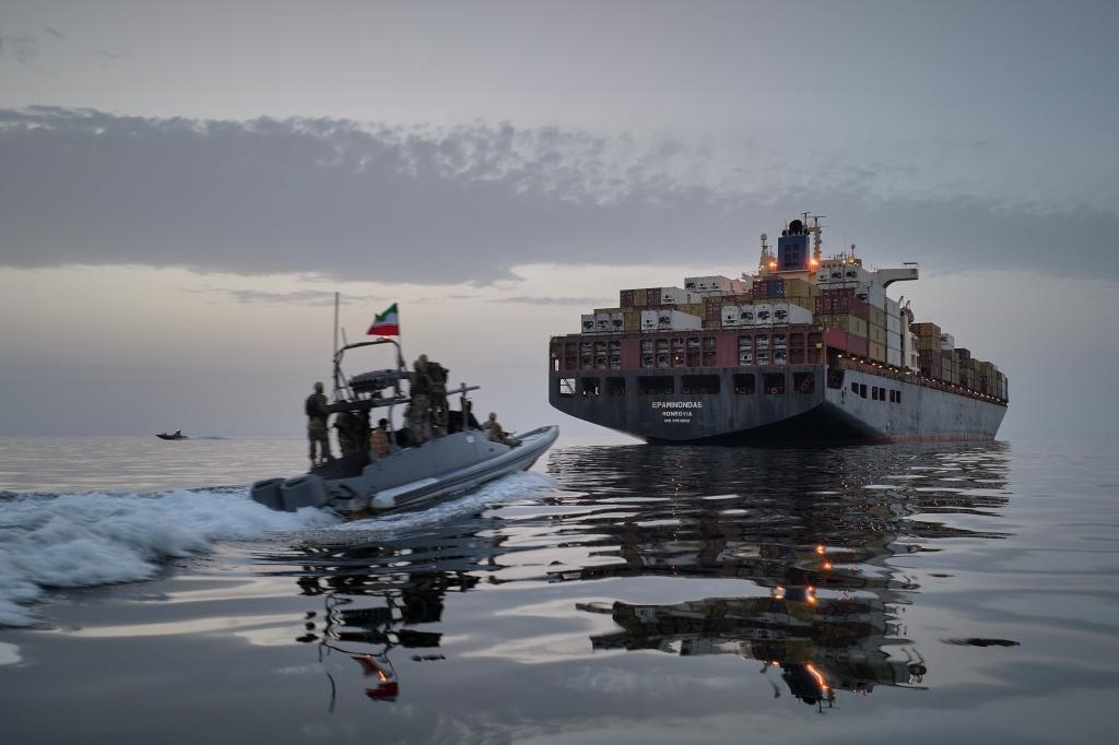 A Revolutionary Guard Navy (IRGC) speedboat approaches the cargo ship