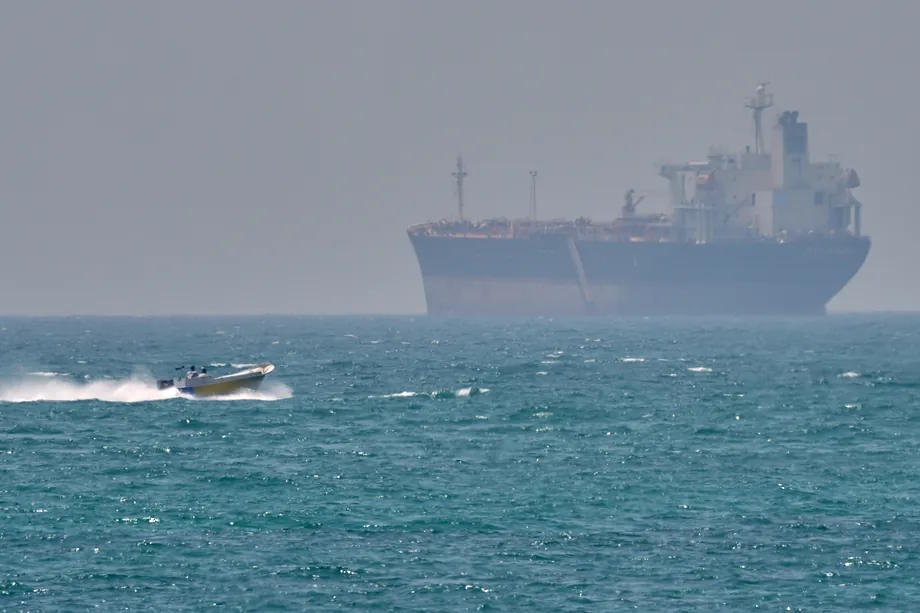 A boat next to an oil tanker anchored in the Strait of Hormuz.