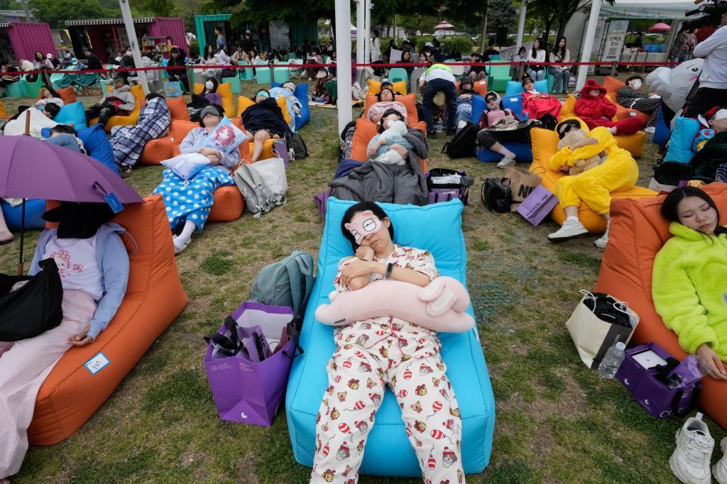 Participants take a nap during the 2026 Hangang Nap Competition at Yeouido Hangang Park in Seoul