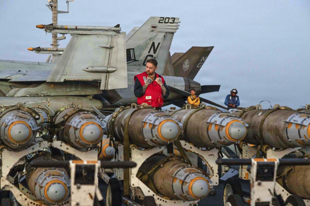 This image provided by U.S. Central Command shows Navy sailors transferring ordnance on the flight deck of Nimitz-class aircraft carrier USS Abraham Lincoln