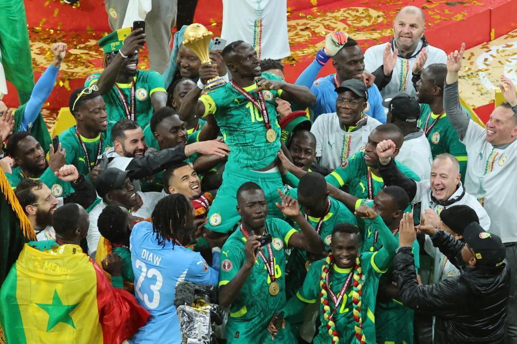Senegal's Sadio Mane holds the trophy aloft as he celebrates with teammates after winning the Africa Cup of Nations