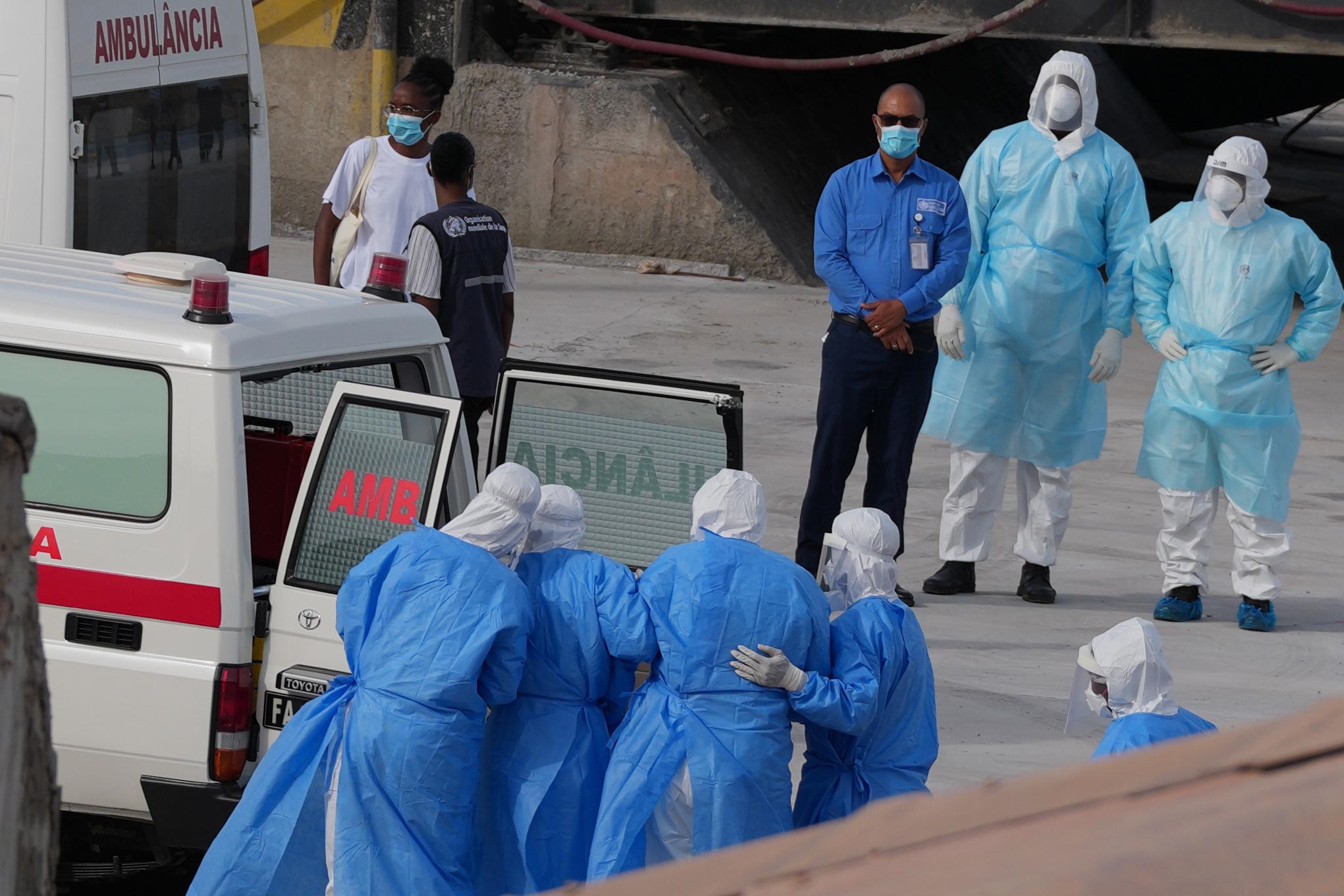 Health workers in protective gear evacuate patients from the MV Hondius.