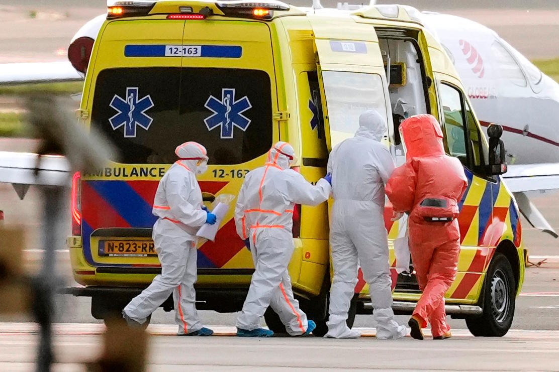 A personal physician accompanies a patient, second from the right, evacuated from the MV Hondius cruise ship.