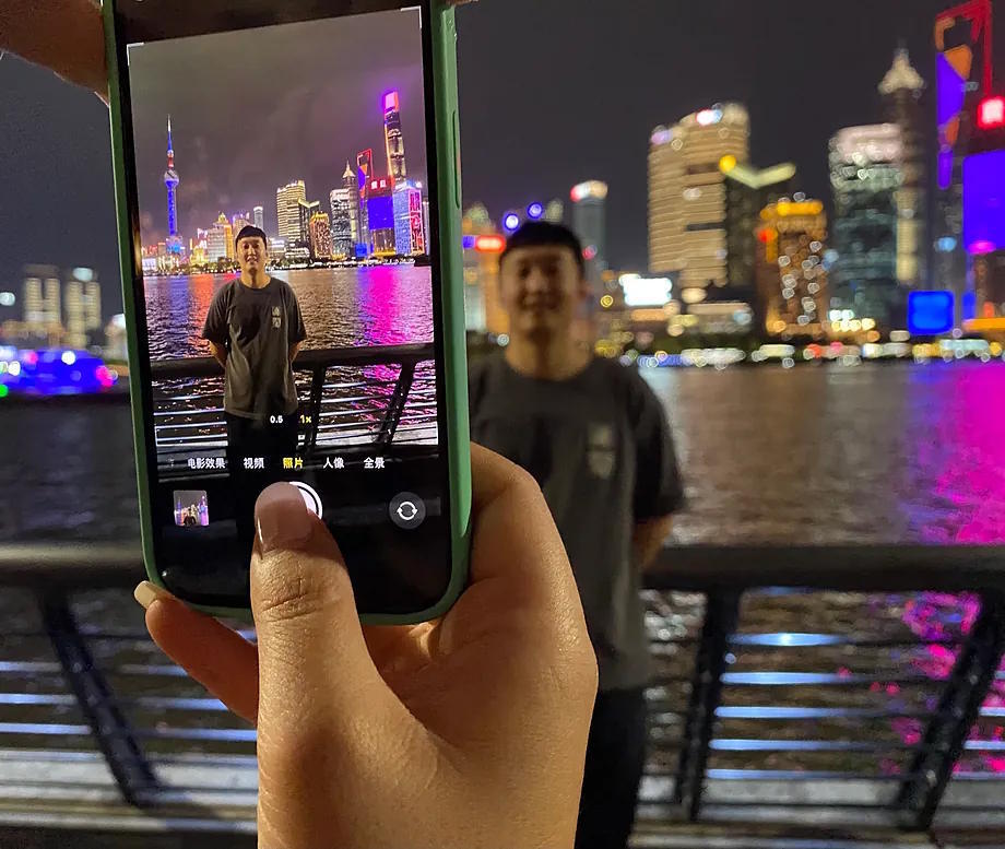 A tourist posing in front of the skyscrapers of Shanghai.