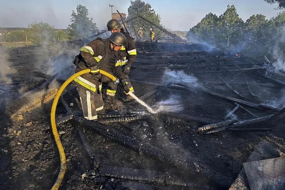 Ukrainian rescuers working at the site where debris from an intercepted Russian drone fell on a kindergarten.