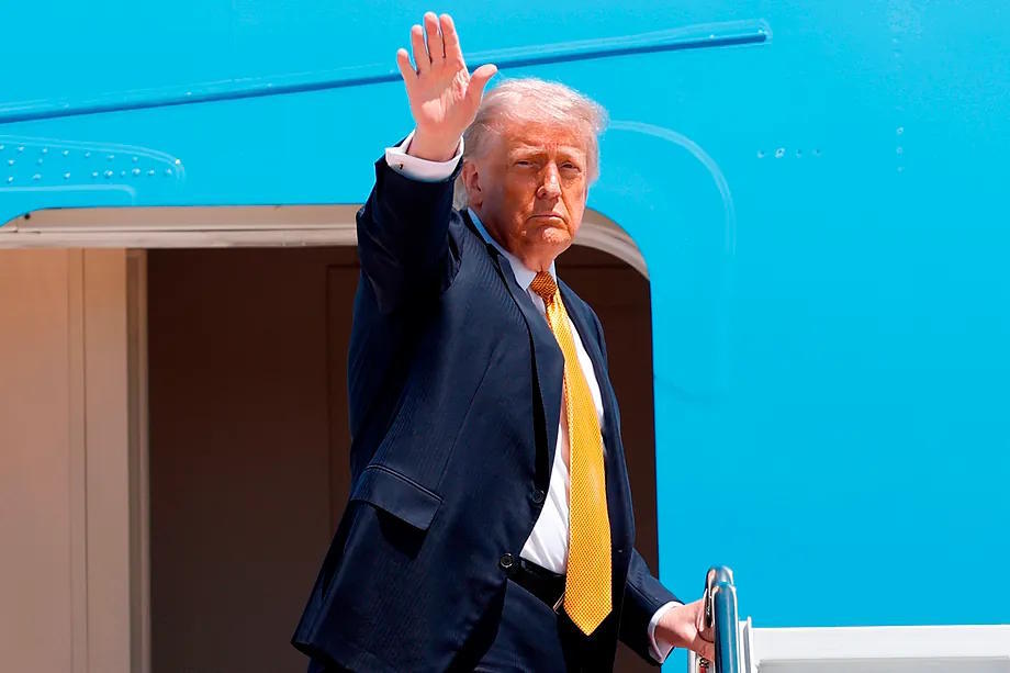 US President Donald Trump waves from the stairs of Air Force One.