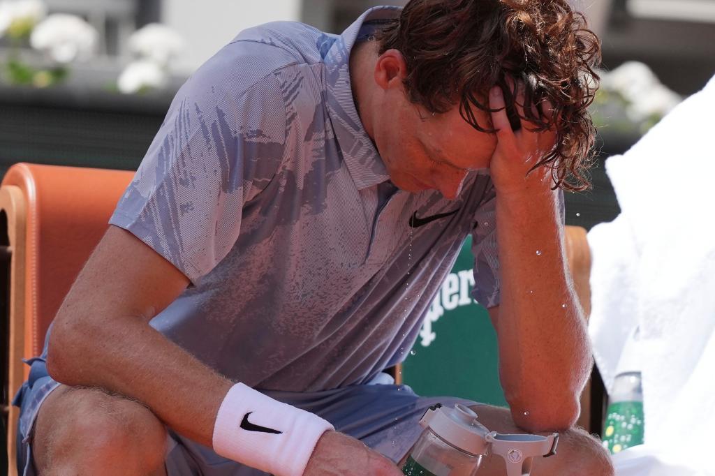 Jannik Sinner of Italy reacts as he cools himself with the water