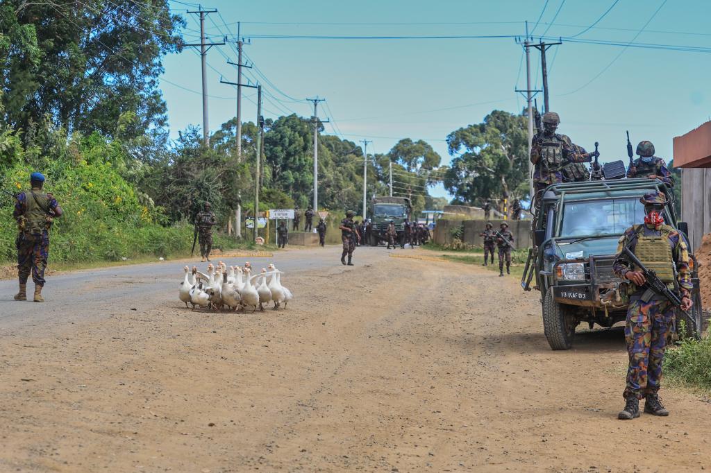 Kenyan soldiers patrol as protesters demonstrate against a proposed Ebola quarantine center to be established by the United States