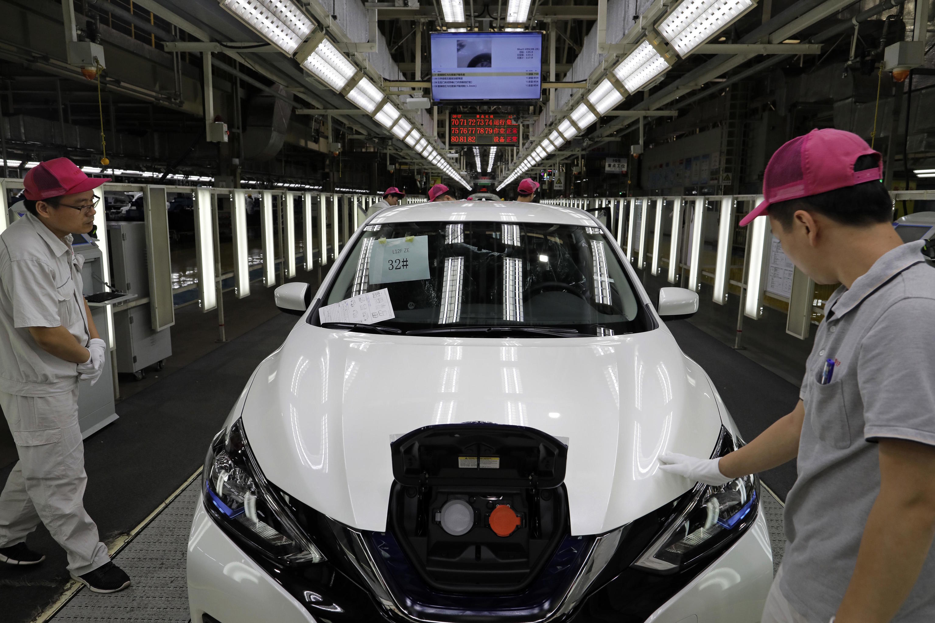 Chinese worker inspect a Nissan Sylphy Zero Emission.