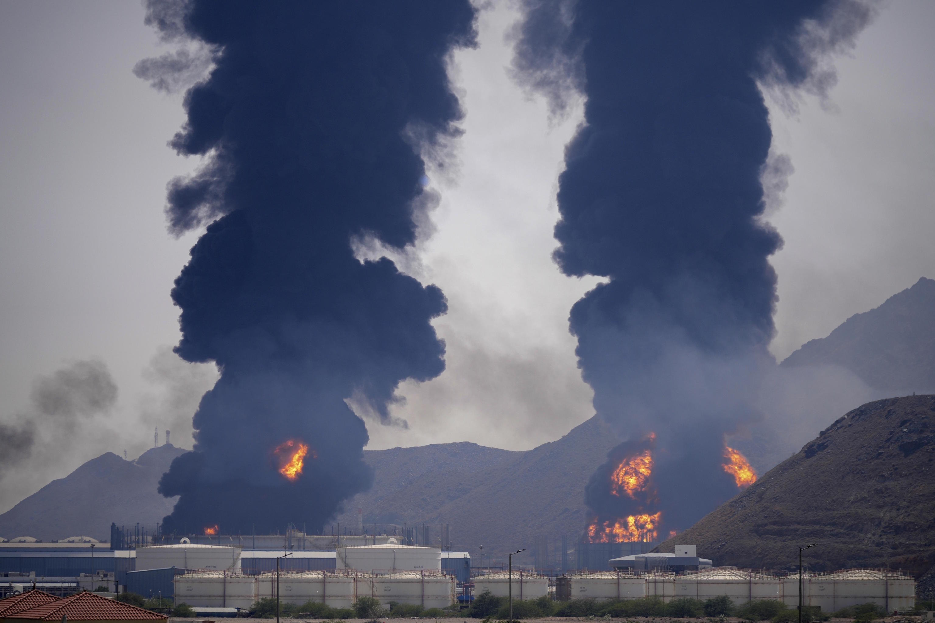 Plumes of smoke and fire rise after debris from an intercepted Iranian drone struck.