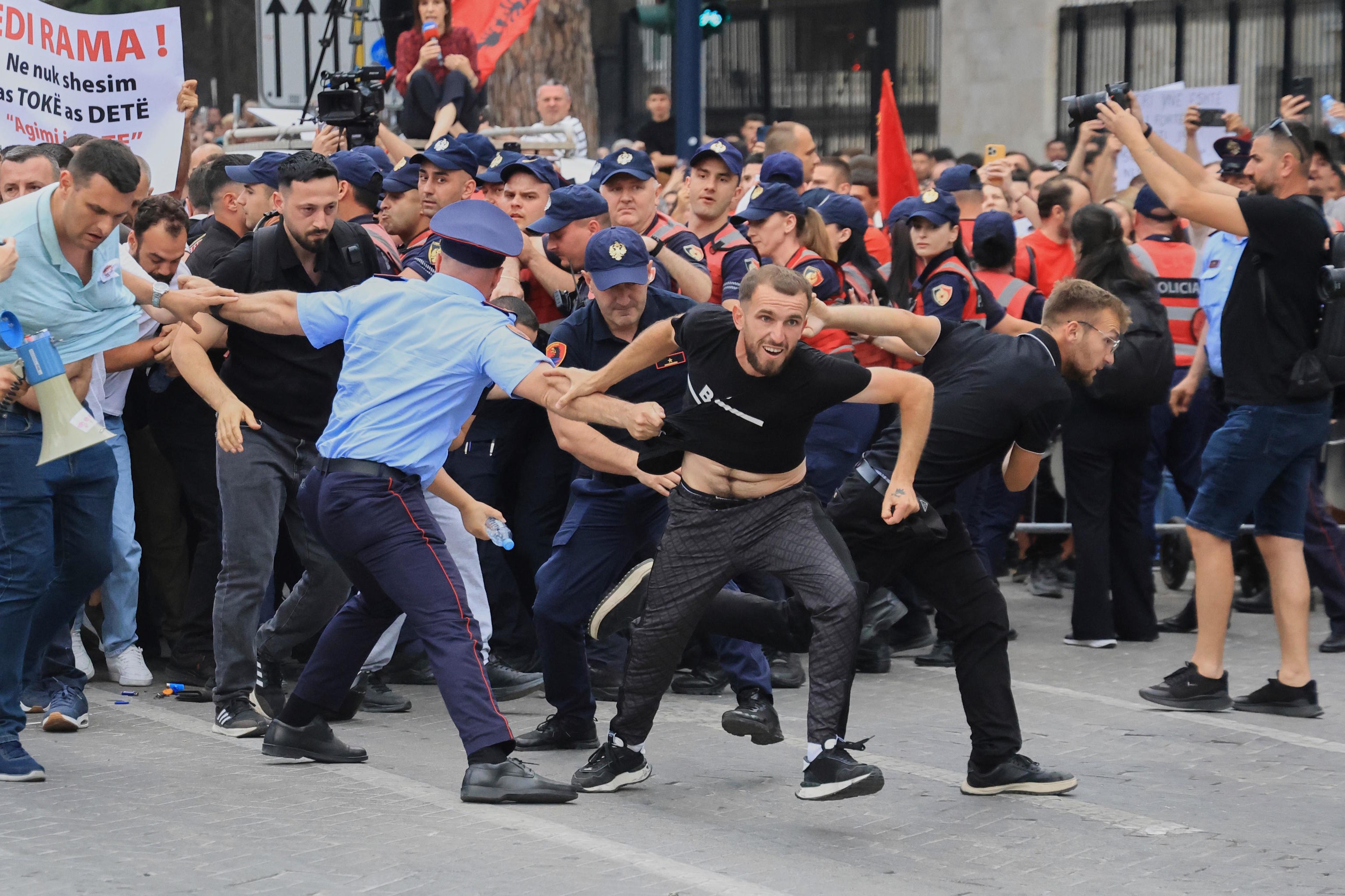 Protesters scuffle with police officers during a demonstration in Tirana.