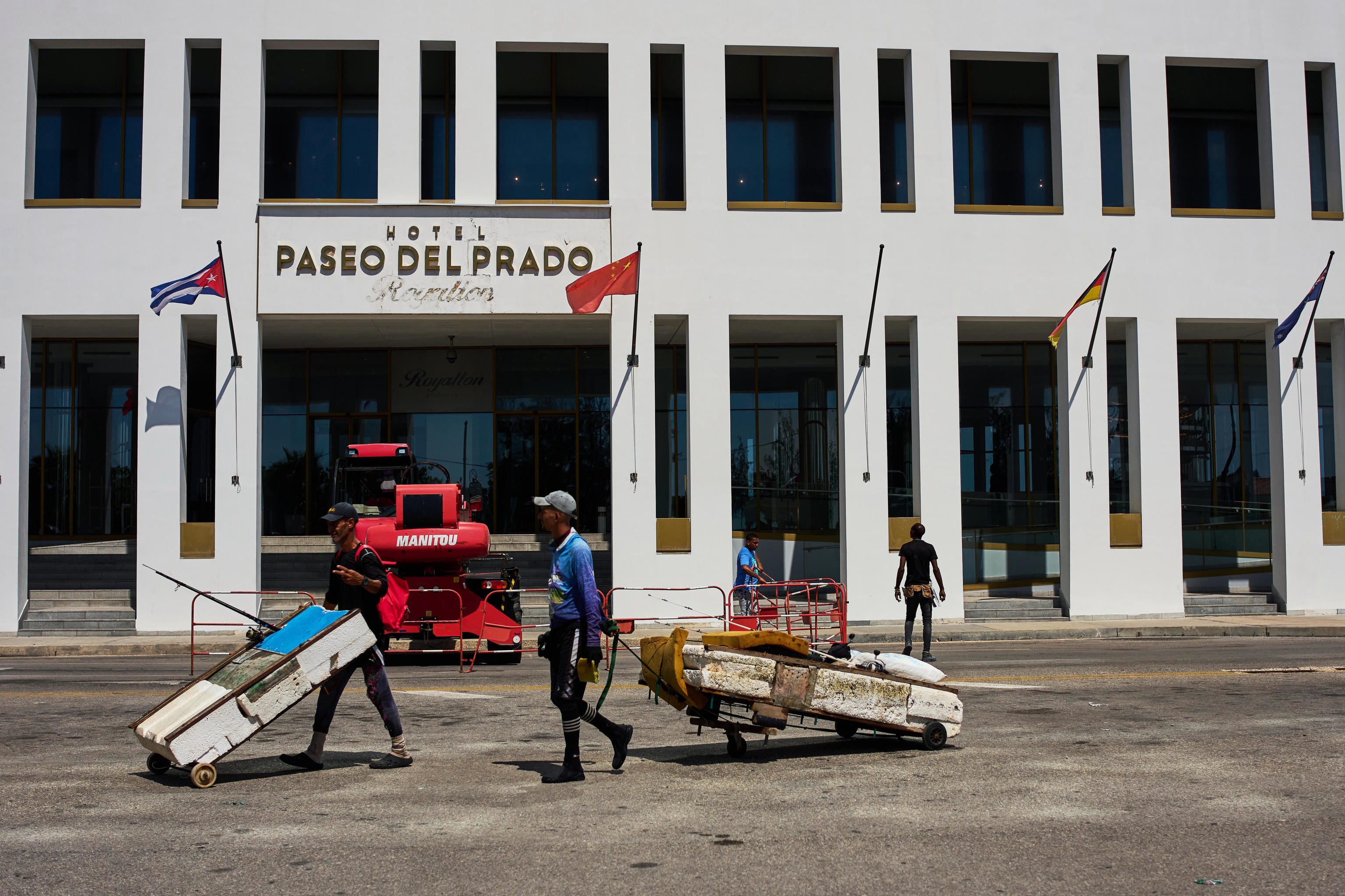 Fishermen with makeshift rafts walk past the Paseo del Prado hotel in Havana.