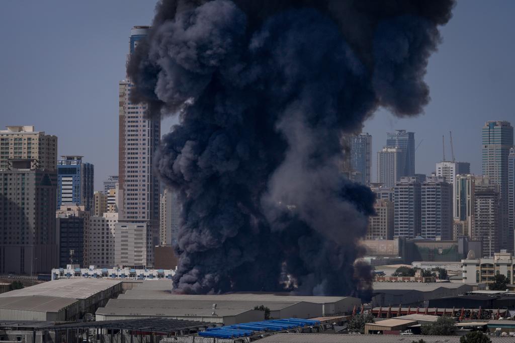 A black plume of smoke rises from a warehouse at the industrial area of Sharjah City in the United Arab Emirates following reports of Iranian strikes in Dubai,