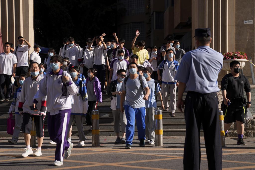 A police officer watches students.