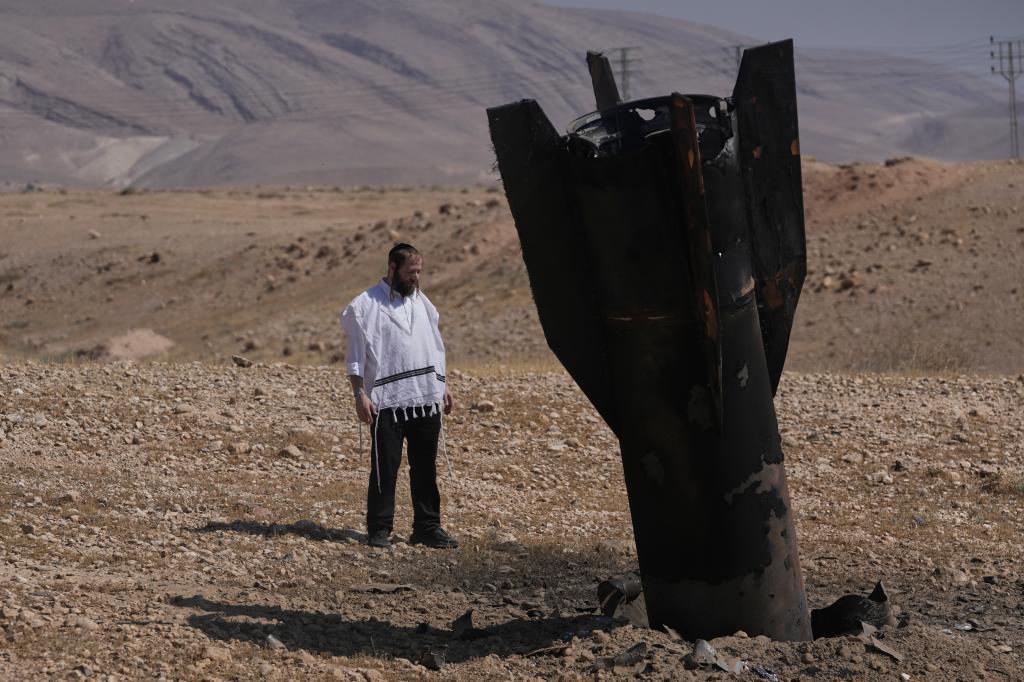 A man look at the wreckage of an Iranian missile.