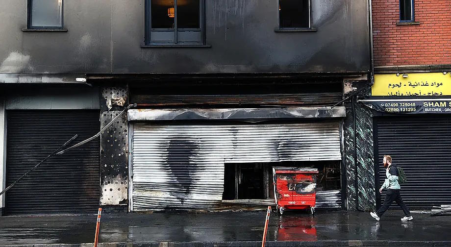 View of a grocery store set on fire next to some apartments after the riots, in downtown Belfast, Northern Ireland.
