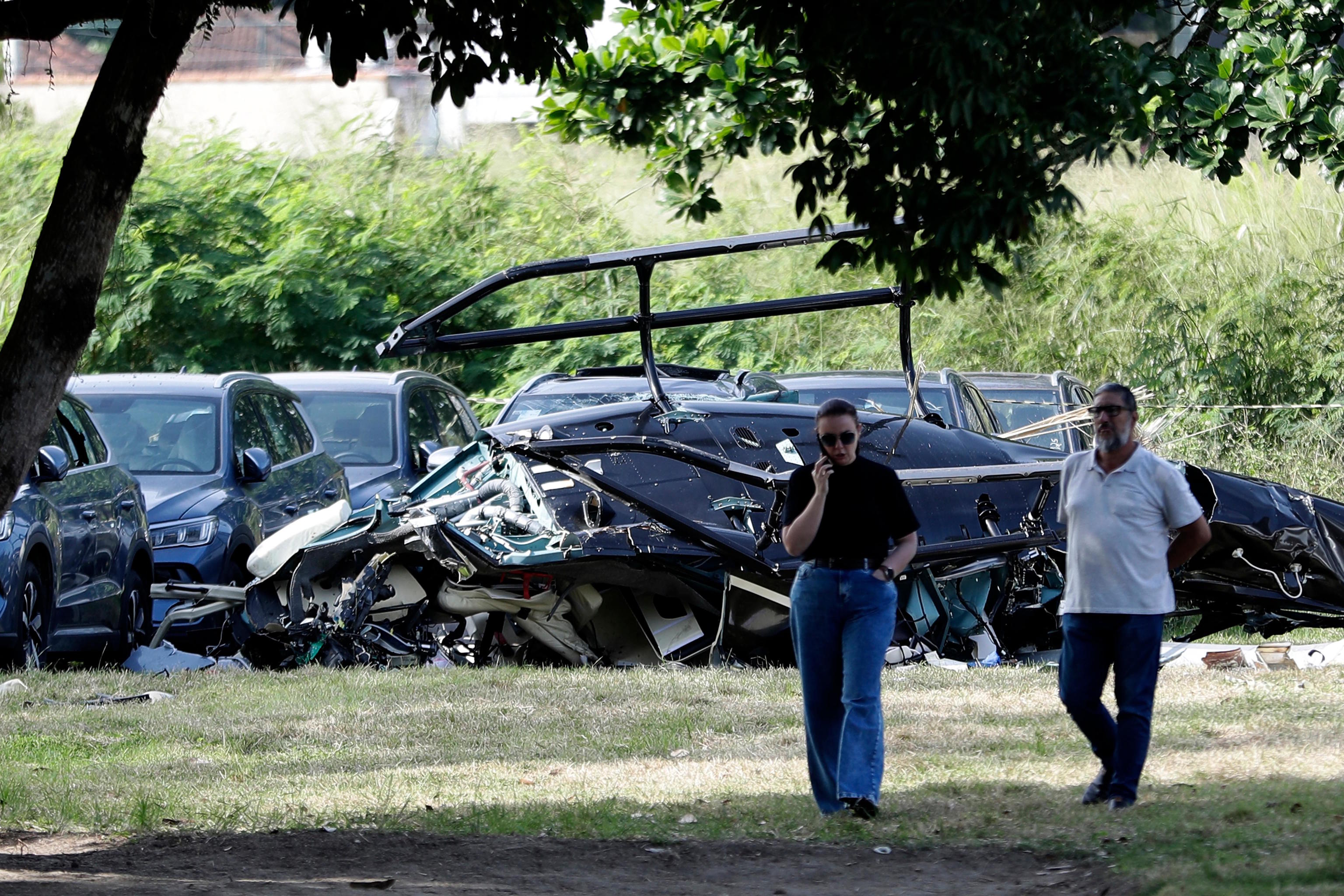 Helicopter wreckage lies at a car dealership parking lot.