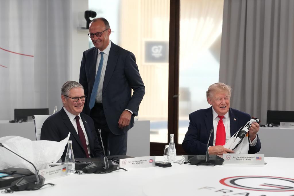 U.S. President Donald Trump, right, smiles after receiving a jersey with the number 47 on it from German Chancellor Friedrich Merz