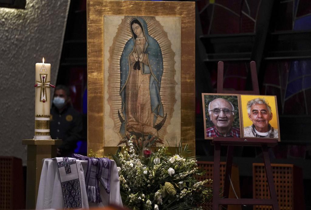 Framed images of Jesuit priests Javier Campos Morales, left, and Joaquin Cesar Mora Salazar are displayed on an altar during a memorial Mass in Mexico City
