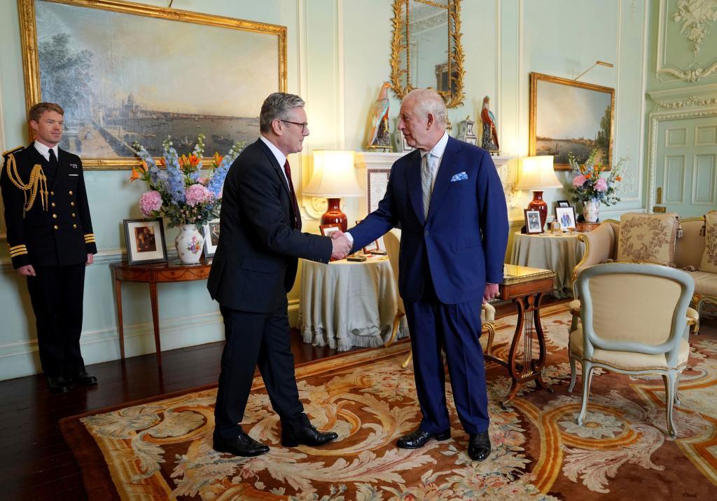 Britain's King Charles III, right, shakes hands with Keir Starmer