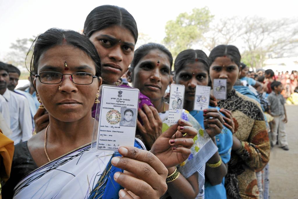 Several women show their identity cards while queuing to vote in Hyderabad
