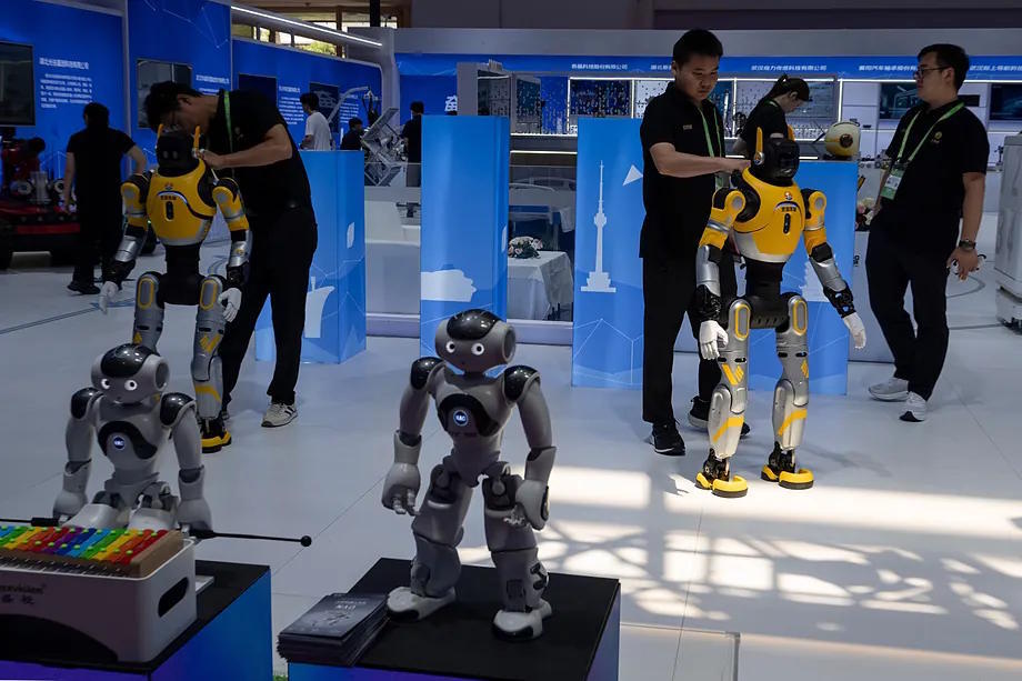 Several workers prepare robots at the China International Supply Chain Exhibition in Beijing.