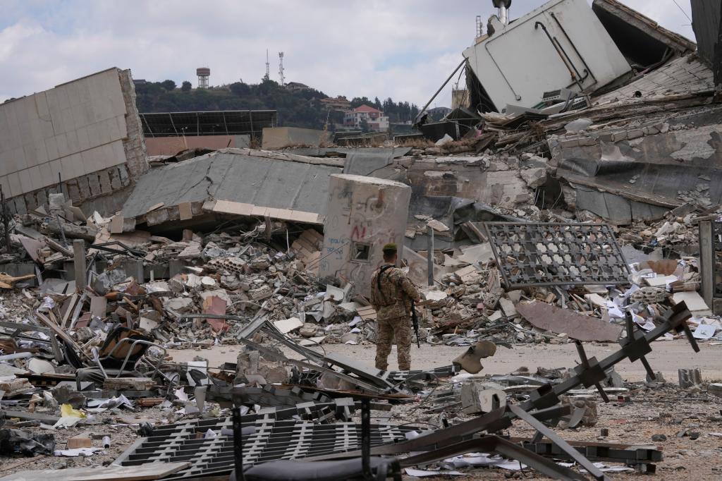 A Lebanese soldier stands in front of a destroyed branch of the Lebanese Central Bank in the town of Nabatiyeh