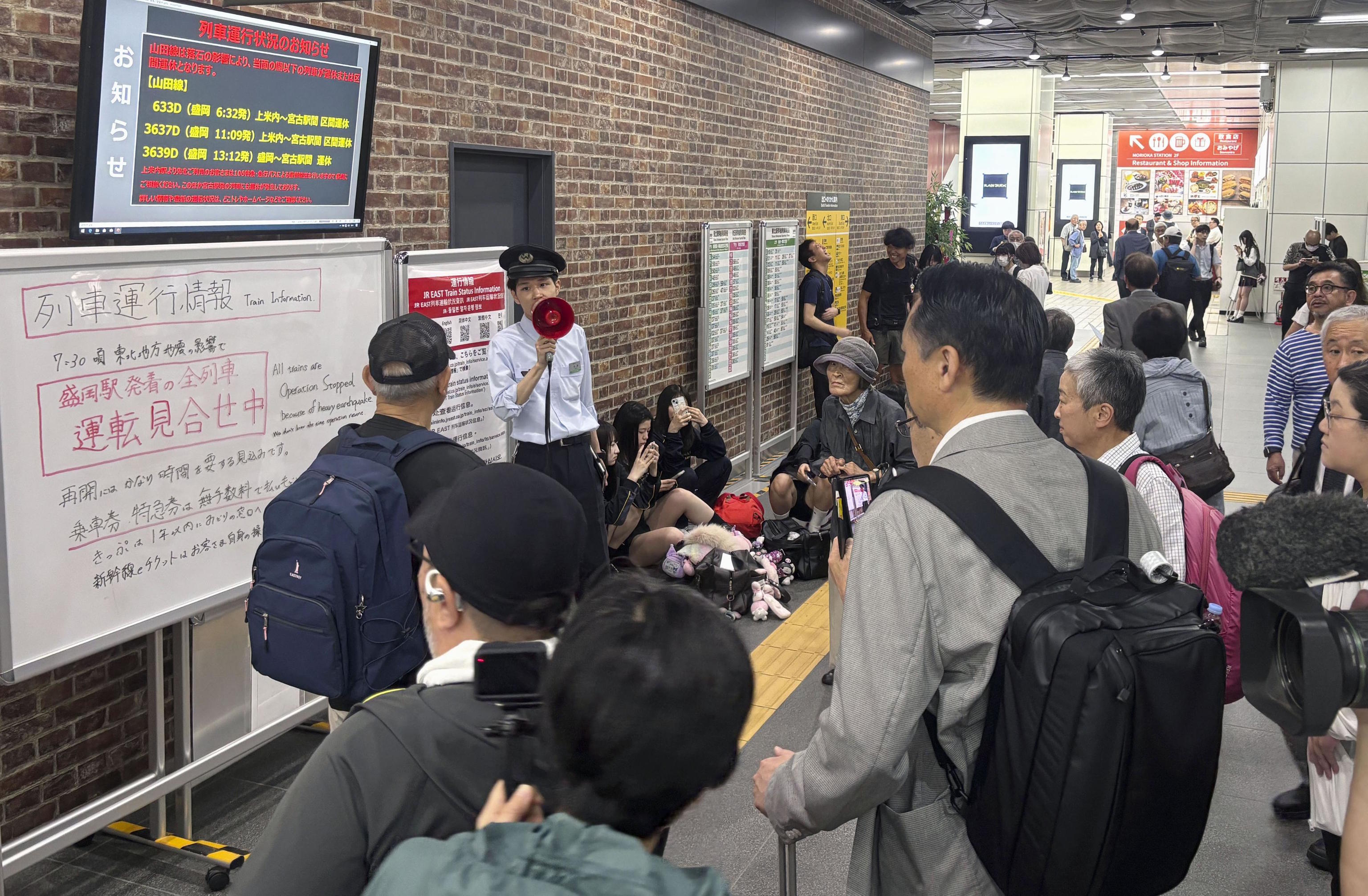 An East Japan Railway Co. station employee provides an update on the status of train services, which were suspended due to an earthquake.