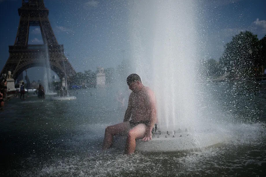 A person cools off in a fountain at the Trocadero, near the Eiffel Tower.