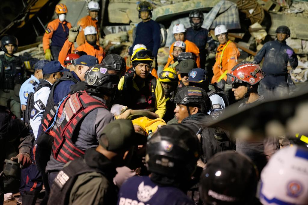 Rescuers search through the rubble of a collapsed building