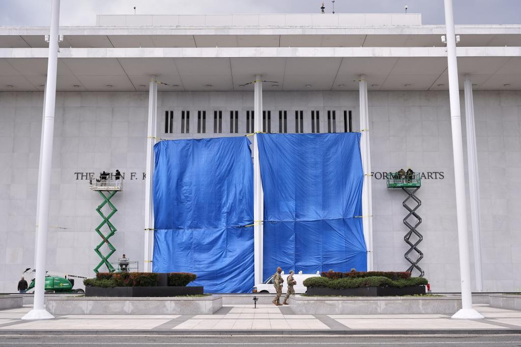 Workers install Donald J. Trump's name above the current signage on the John F. Kennedy Memorial Center