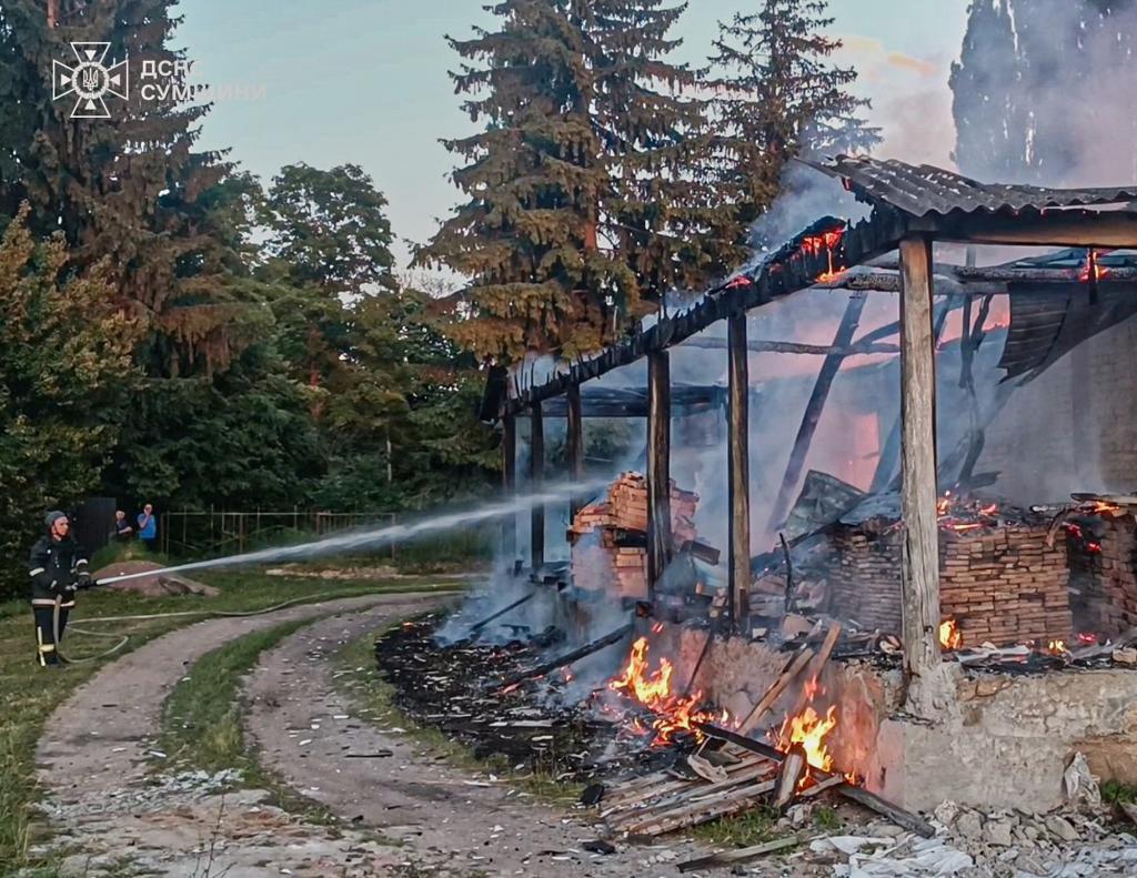 Firefighters extinguish a fire in a residential building following a Russian drone attack in Sumy region
