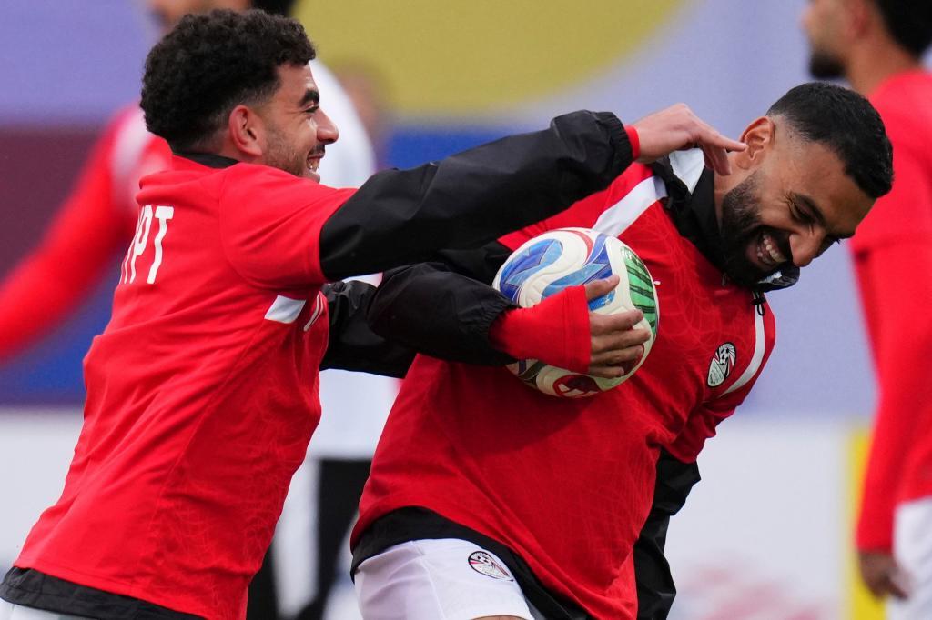 Egypt's Tarek Alaa (24), left, jokes with his teammate Egypt's Mohamed Salah (10)