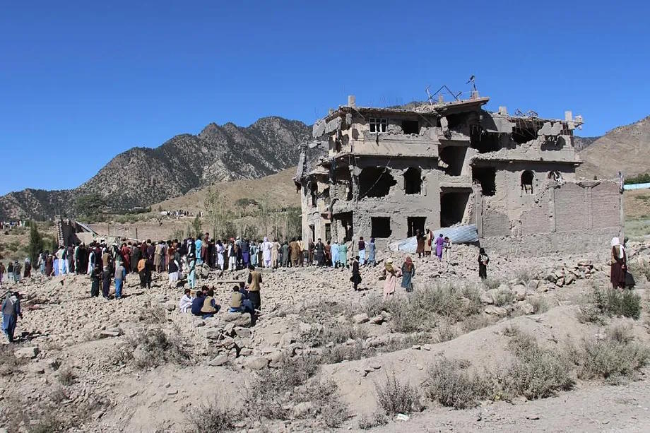 Residents walk among the rubble caused by Pakistani bombings.