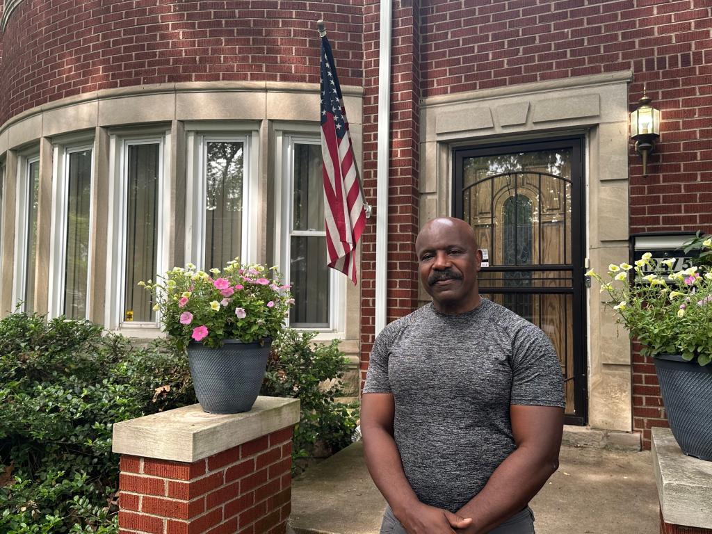 Jerry Esters stands in front of American flag outside his Detroit home
