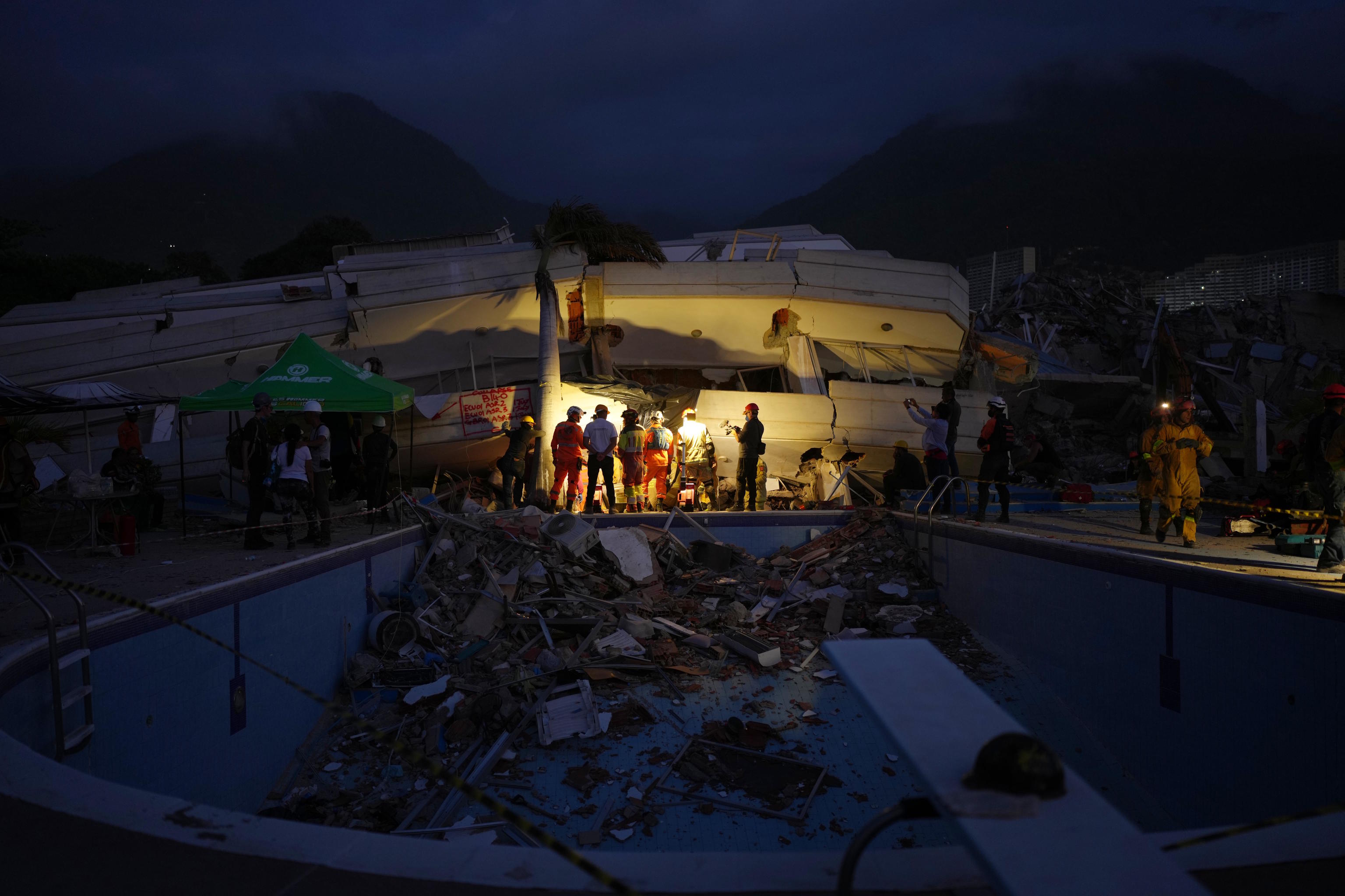 Rescue workers inspect a building that collapsed in twin earthquakes in La Guaira.