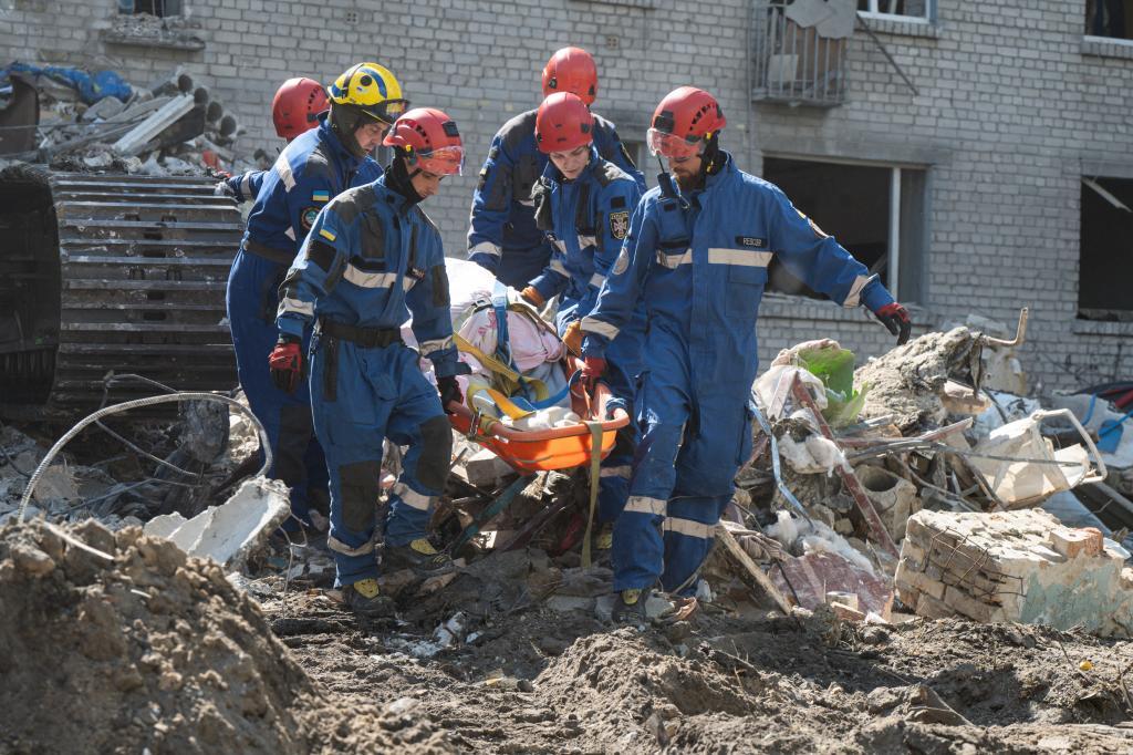 Rescuers clear the rubble after Russian missiles hit residential buildings during a massive air attack in Kyiv