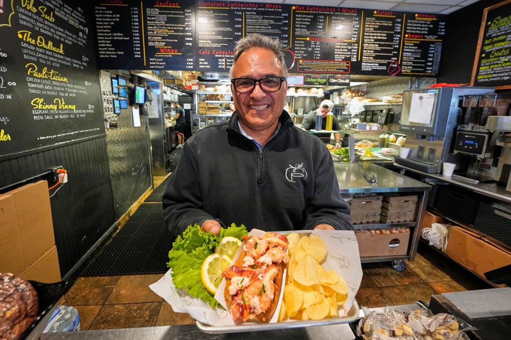 Principal Paul Barker serves lobster rolls to World Cup tourists at Pauli's sandwich shop in the North End of Boston