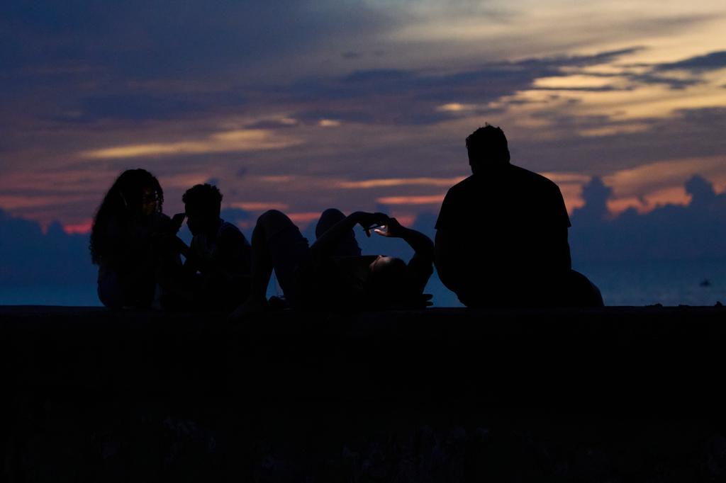 People spend time sitting on the Malecón seawall during a blackout in Havana, Cuba.