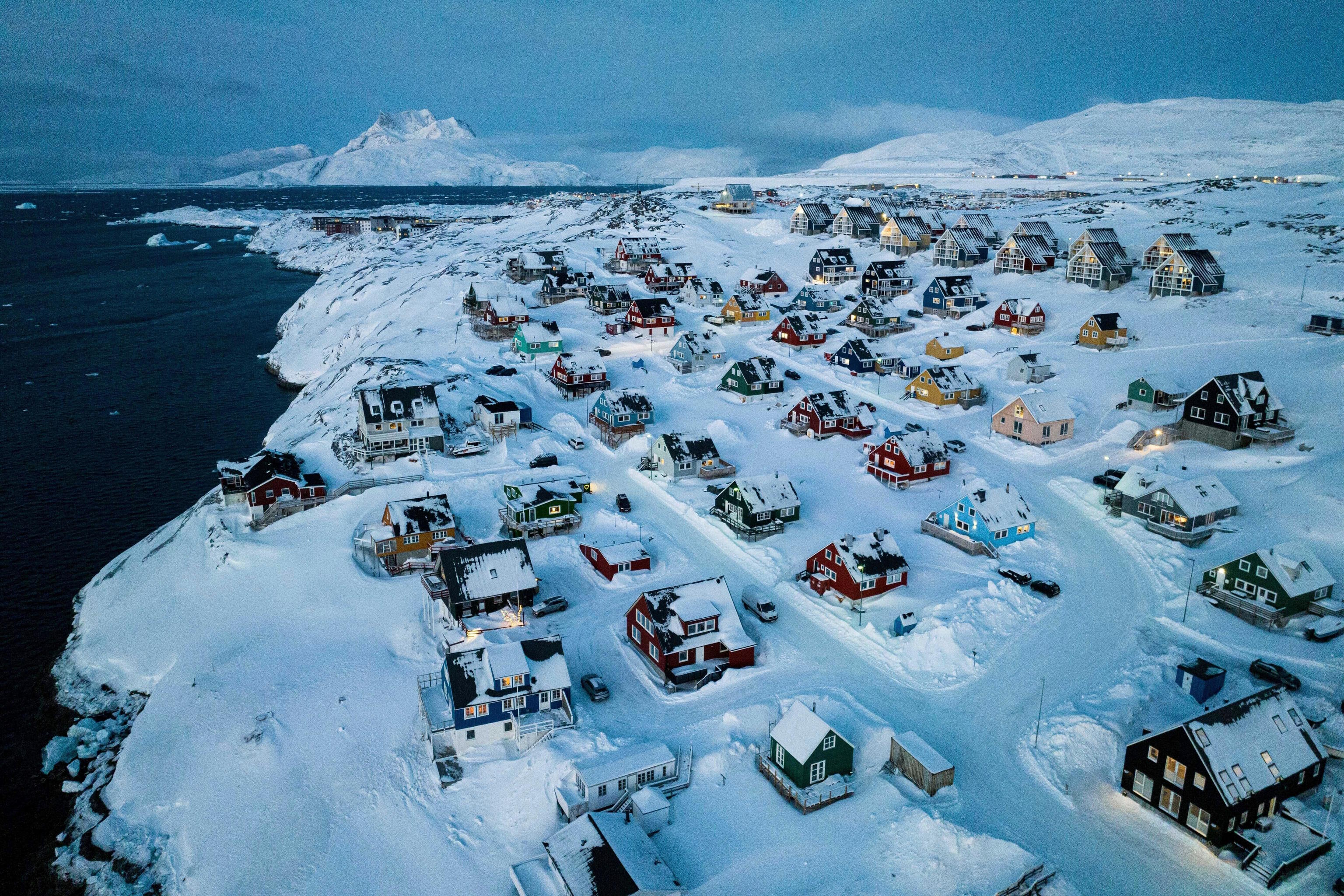 Houses covered in snow are seen on the coast of a sea inlet of Nuuk, Greenland.