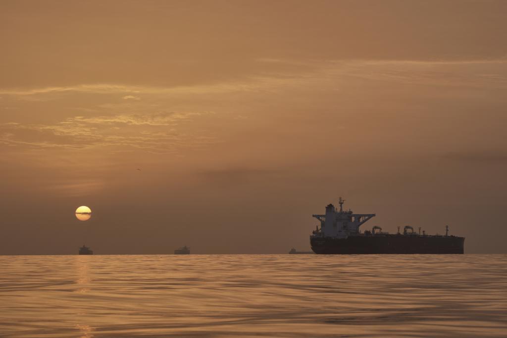 The sun rises behind tankers anchored in the Strait of Hormuz off the coast of Qeshm Island