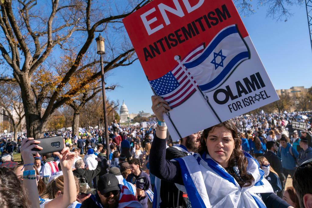 A woman holds a sign saying, "end antisemitism" while attending a March for Israel