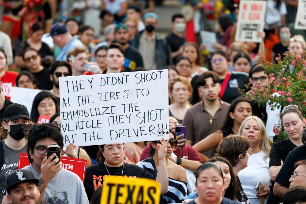A woman holds a sign during a vigil in honor of Lorenzo Salgado Araujo