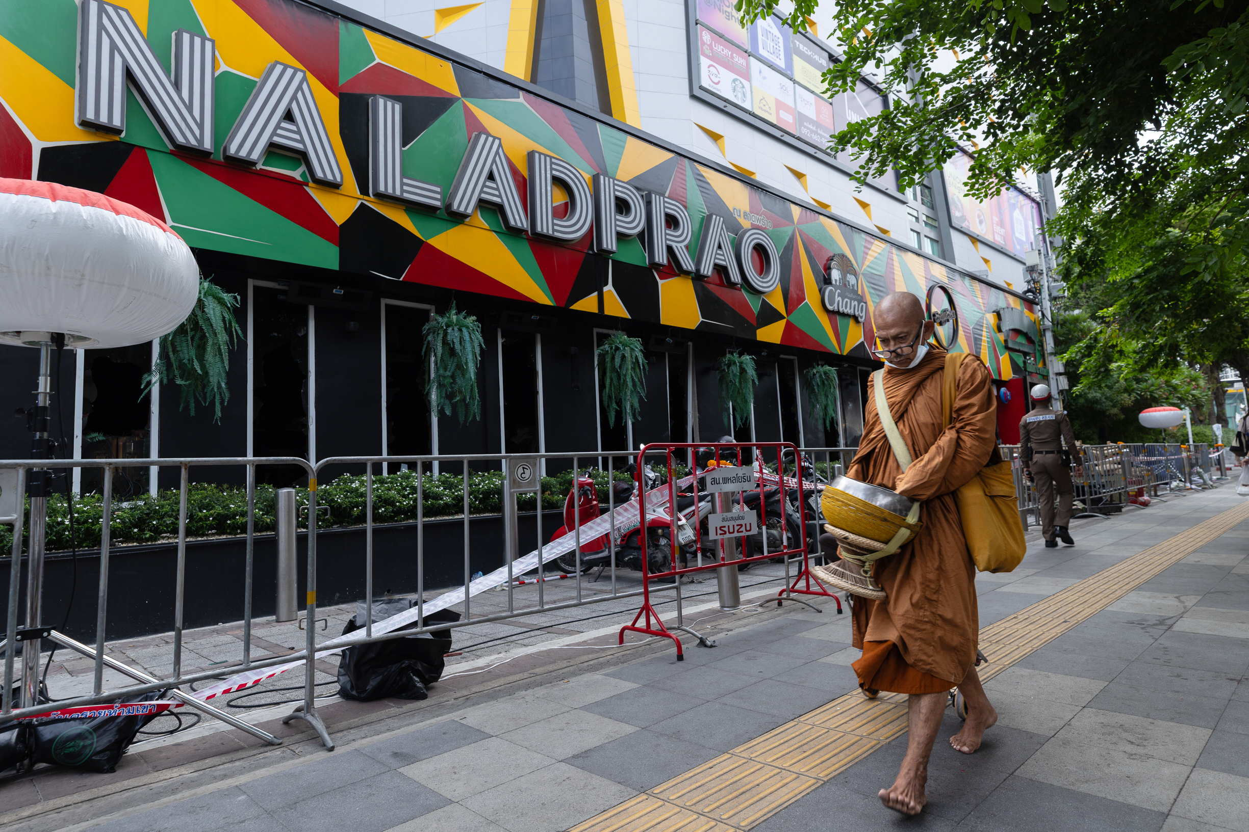 A Buddhist monk walks outside the music bar where a fire killed a number of people in Bangkok.