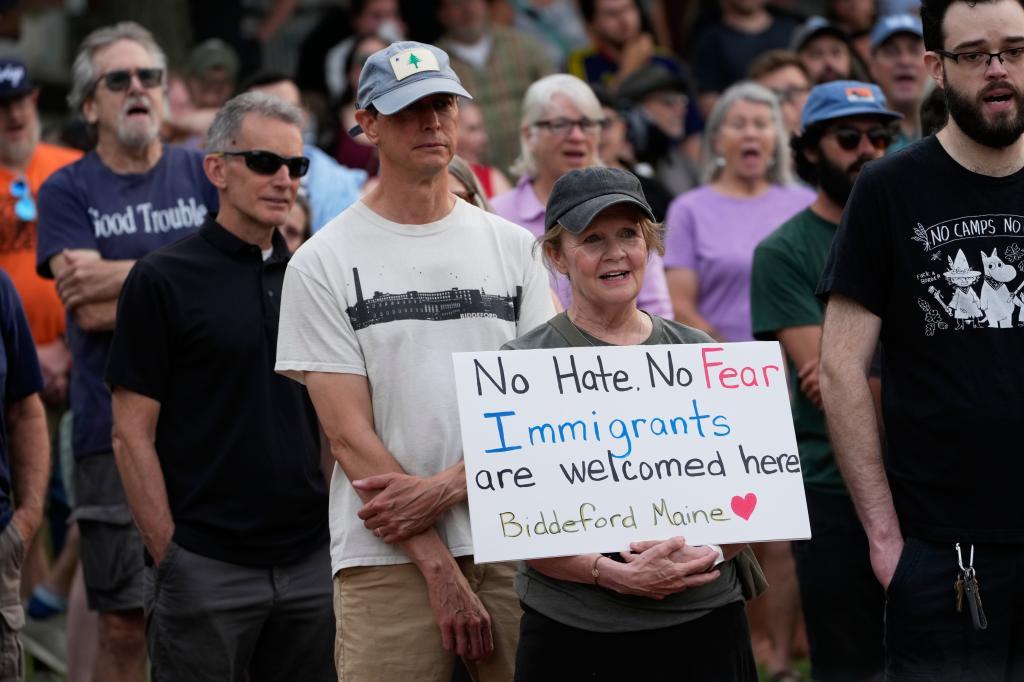 A demonstrator holds a sign after a man was shot and killed by U.S. Immigration and Customs Enforcement