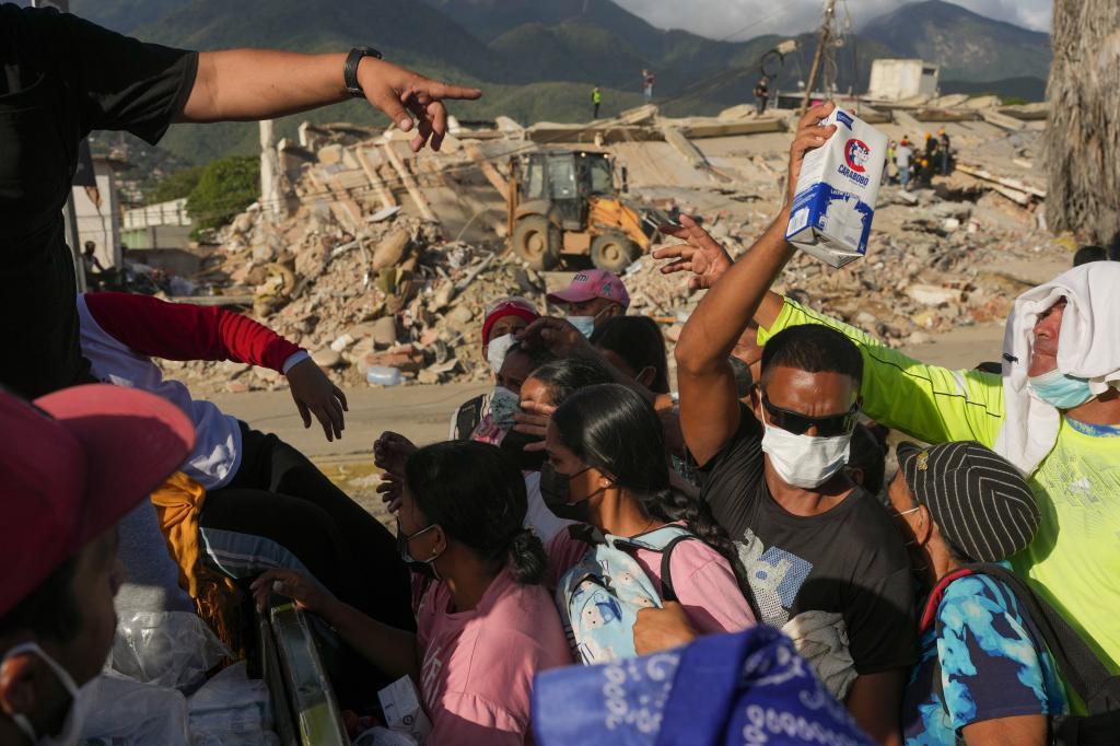 People affected by the earthquakes line up for food in La Guaira,