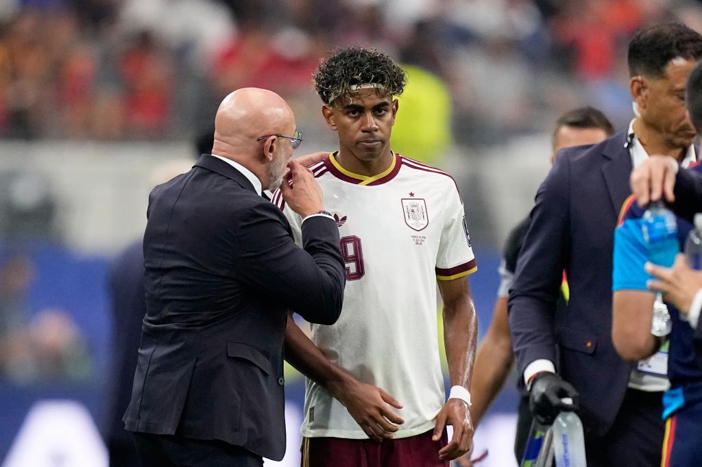 Spain head coach Luis de la Fuente speaks to Spain's Lamine Yamal